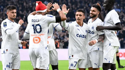 Alexis Sánchez celebra un gol con Dimitri Payet. A su lado izquierdo, con barba, el carrilero Jonathan Clauss.