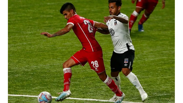 Erick Wiemberg protege el balón ante la insistente presión de Marcos Bolados en un partido entre Unión La Calera y Colo Colo.
