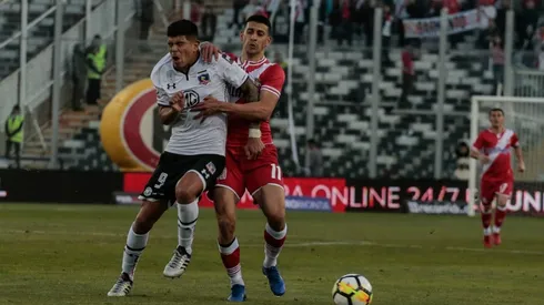 Nicolás Gauna disputa un balón con Esteban Pavez en un duelo entre Colo Colo y Curicó Unido.