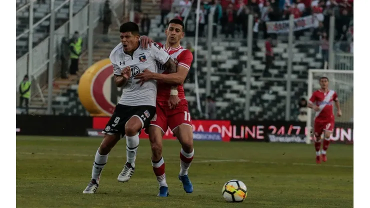Nicolás Gauna disputa un balón con Esteban Pavez en un duelo entre Colo Colo y Curicó Unido.