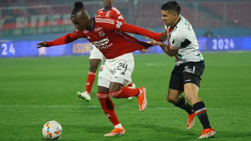 Jonathan Benítez pelea con José Ortiz en el partido entre Palestino e Independiente Medellín.