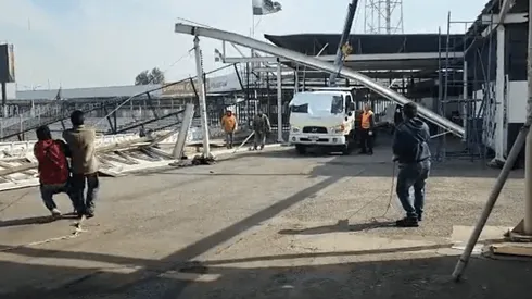 Trabajadores despejan el sector colapsado del estadio Monumental sin casco.