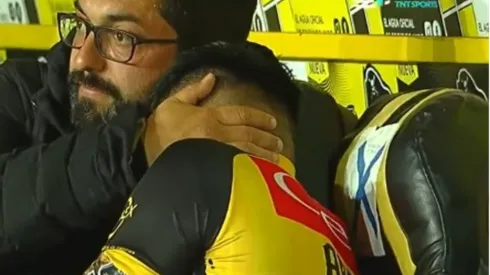 El médico de Coquimbo Unido, Rodrigo Araya, intenta consolar a Joe Abrigo tras su rotura del tendón de Aquiles. (Captura TNT Sports).