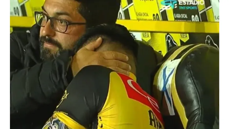 El médico de Coquimbo Unido, Rodrigo Araya, intenta consolar a Joe Abrigo tras su rotura del tendón de Aquiles. (Captura TNT Sports).