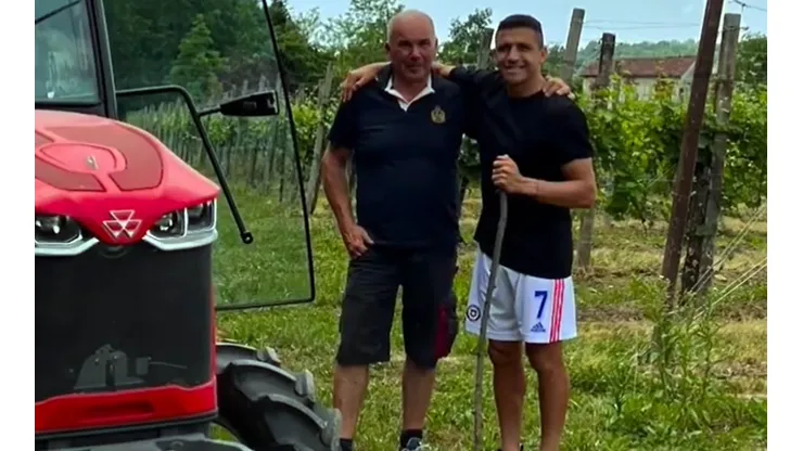Alexis posa con su nueva viña de fondo y enólogos lo felicitan.