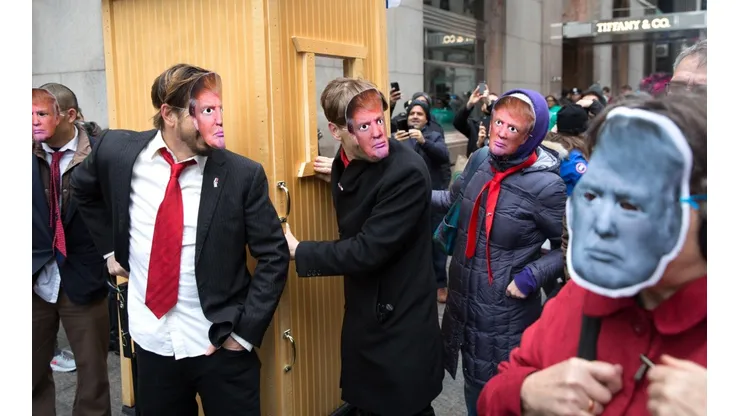 Personas usan máscaras del ex presidente Trump como parte del 32 ° Desfile Anual del Día de los Inocentes en Nueva York