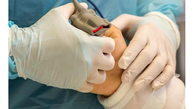 Un enfermero de la UCI del Hospital Base San José de Osorno sostiene la mano de un paciente intubado.