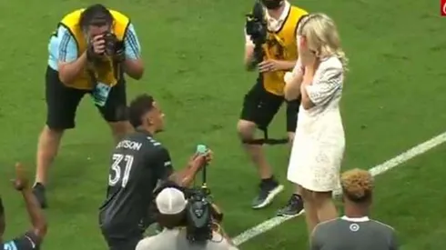 Hassani Dotson arrodillado frente a su novia