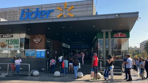 Personas haciendo fila en supermercado Líder