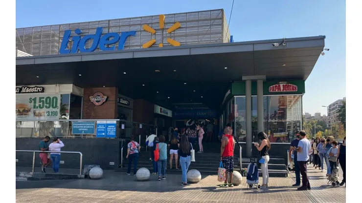 Personas haciendo fila en supermercado Líder