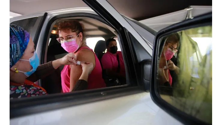 Operativo de inoculación al auto a personas sanas en Espacio Riesco