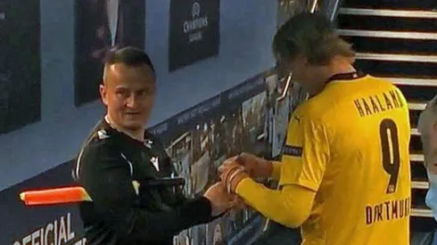 Haaland firmando las tarjetas del árbitro tras el Manchester City vs Borussia Dortmund