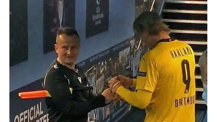 Haaland firmando las tarjetas del árbitro tras el Manchester City vs Borussia Dortmund