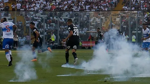 Blandi sufriendo la agresión de gente que entró a la fuerza y con pirotecnia al partido de Colo Colo con la UC con la intención de suspenderlo, algo que consiguieron.