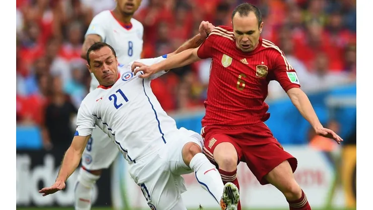 Andrés Iniesta disputa el balón con Marcelo Díaz en el Mundial 2014