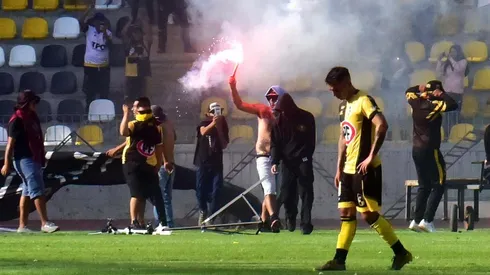 Hinchas ingresan a la cancha del estadio.