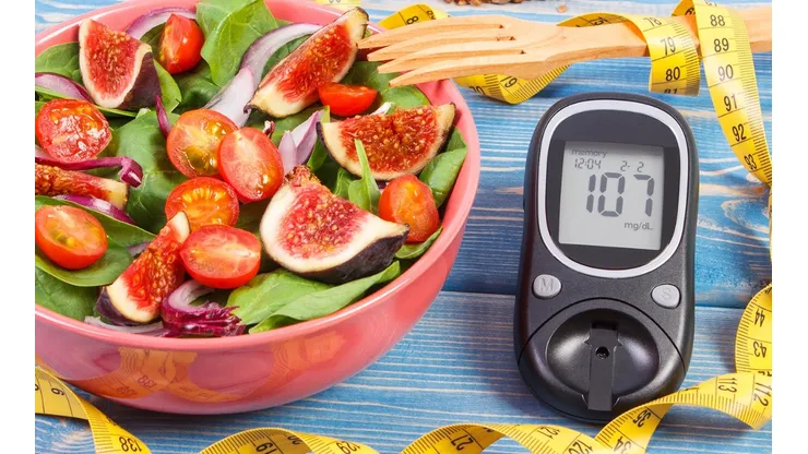 Fruit and vegetable salad and glucometer with tape measure, concept of diabetes, slimming and healthy nutrition