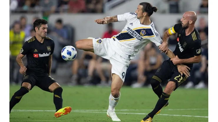 Los Angeles Galaxy forward Zlatan Ibrahimovic (9) fights for the ball against Los Angeles FC midfielder Benny Feilhaber (33) and defender Laurent Ciman (23) during the first half of a Major League Soccer match at Banc of California Stadium in Los Angeles, Calif. on Thursday July 26, 2018. (Photo by Raul Romero Jr, Contributing Photographer)