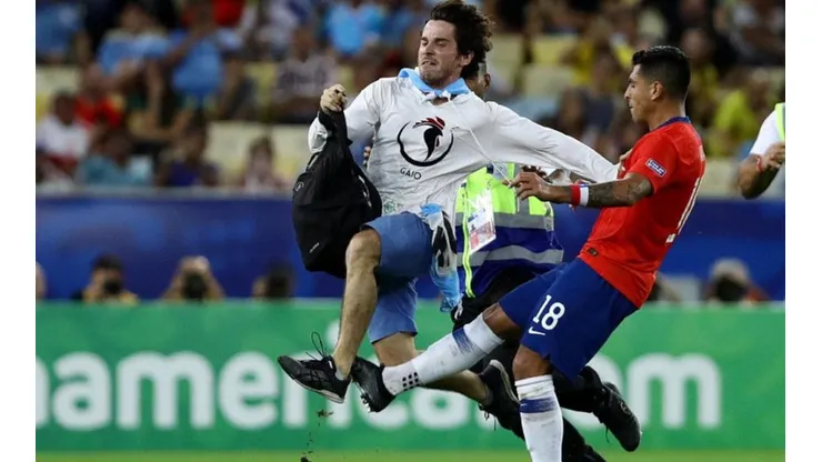 Gonzalo Jara frenando al hincha que entró a la cancha (Foto: Getty Images)