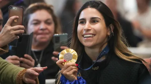 Francisca Crovetto muestra su medalla de oro en el arribo al país.