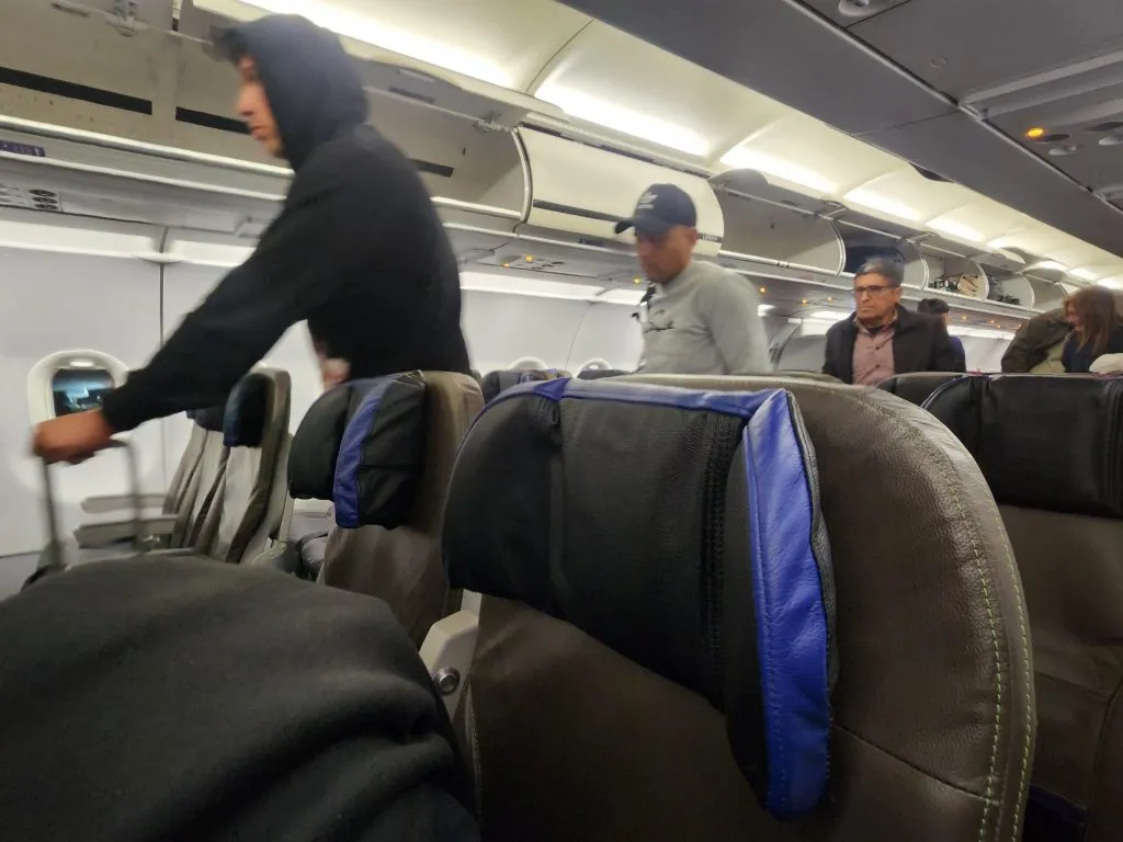 Brayan Cortés, tapado con gorro, bajando del avión en Santiago. Foto: Emisora Bullanguera.