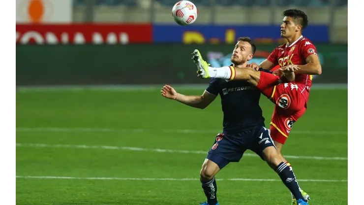 Thomas Galdames pelea una pelota con Ángelo Henríquez. El zurdo defensor se irá de Unión Española.