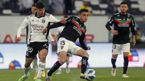 Vicente Fernández disputa un balón con Alexander Oroz en un partido entre Colo Colo y Palestino.