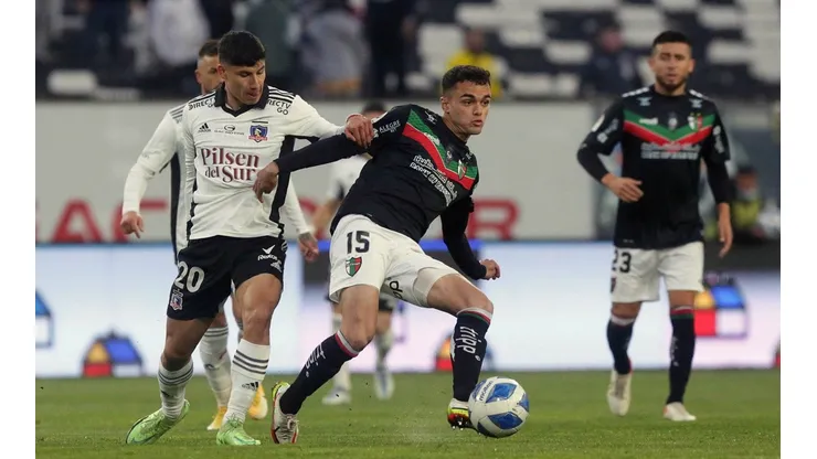 Vicente Fernández disputa un balón con Alexander Oroz en un partido entre Colo Colo y Palestino.