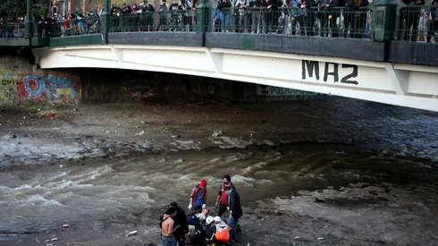 Rescatistas llegan a socorrer a joven lanzado al río Mapocho | Foto: Agencia Uno