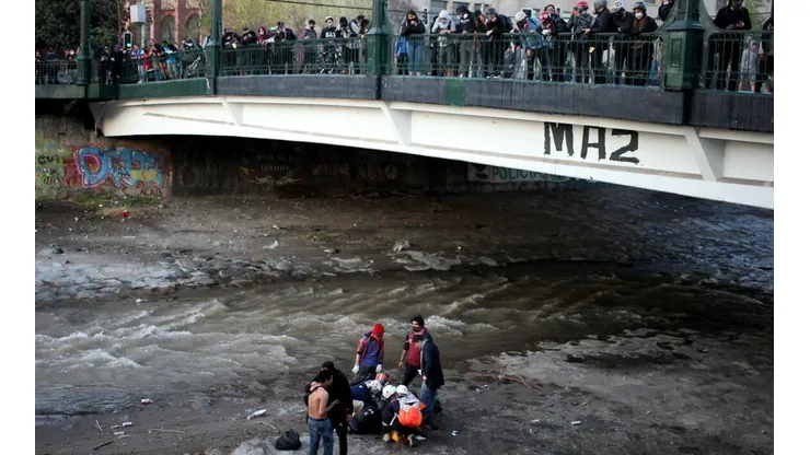 Rescatistas llegan a socorrer a joven lanzado al río Mapocho | Foto: Agencia Uno