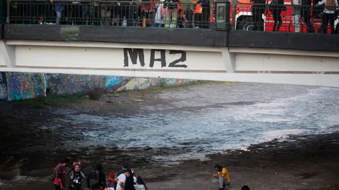 Rescatistas ayudan a joven tras caída al río Mapocho | Foto: Agencia Uno