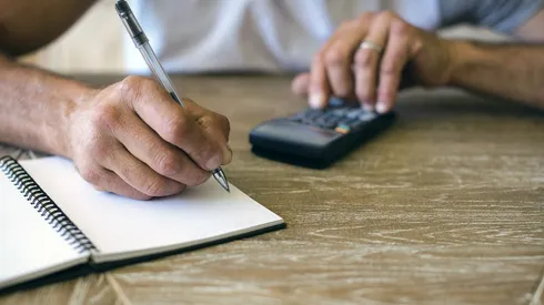 Man using calculator to calculate expenses