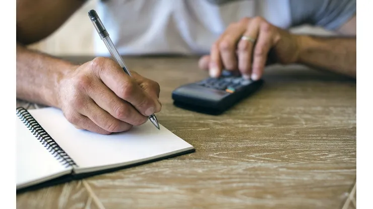 Man using calculator to calculate expenses
