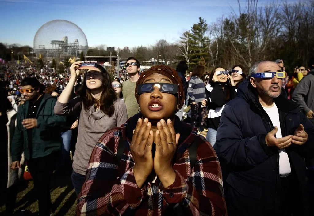 Personas mirando un eclipse solar con lentes apropiados