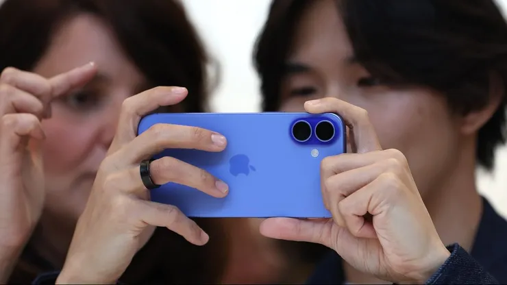 Un asistente inspecciona el nuevo iPhone 16 Pro Max durante un evento especial.