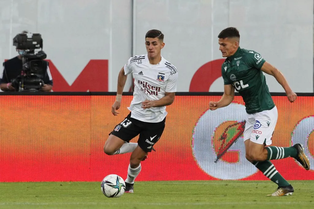 Lucas Cepeda en acción ante Colo Colo por Santiago Wanderers. Persigue a Bruno Gutiérrez. (Dragomir Yankovic/Photosport).
