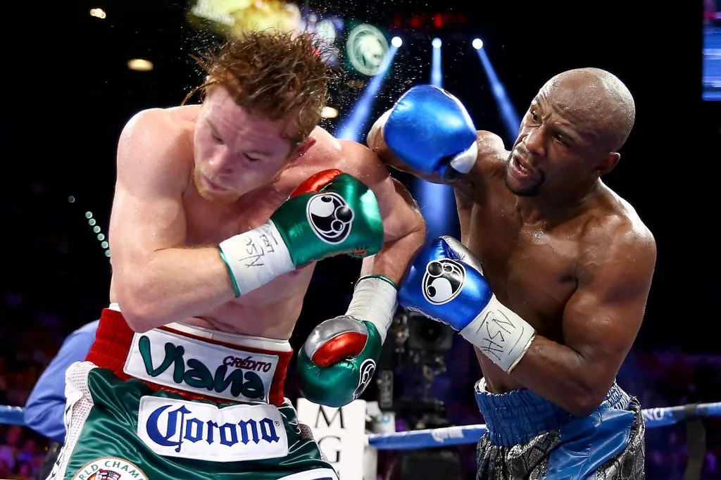 Floyd Mayweather Jr. lanza un derechazo a la cabeza de Canelo Álvarez durante su pelea por el título de las 154 libras del CMB y la AMB en 2013 (Getty Images).