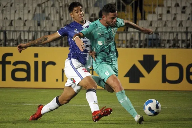 El jugador de Deportes Antofagasta, Eric Ahumada, disputa el balón contra Tomás Molina deLiga Universitaria de Quito (2022) (Photosport).