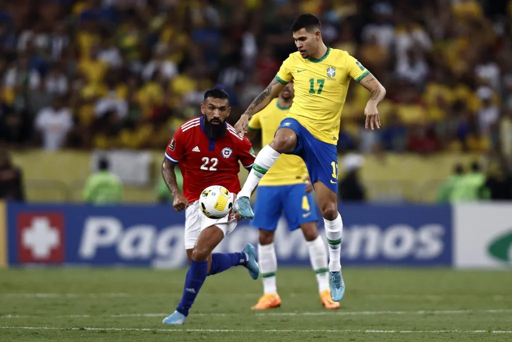 Bruno Guimaraes juega una pelota ante la mirada de Ronnie Fernández. (Buda Mendes/Getty Images).
