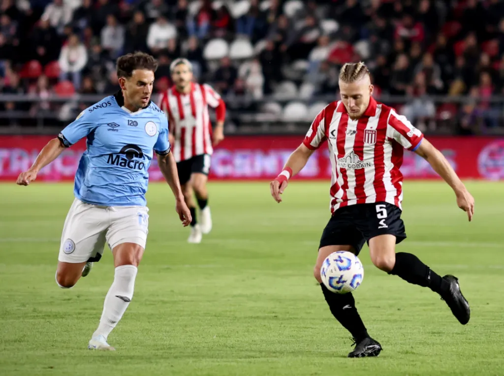 Santiago Ascacíbar con el balón ante la marca del ex UC Lucas Menossi. (Foto: Estudiantes de La Plata).