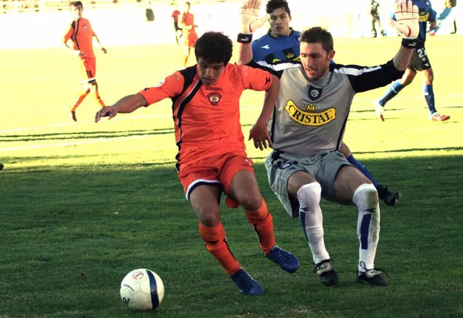 Alexis Sánchez ante Cristian Muñoz, el Tigre, en Huachipato. (CALAMA. CHILE PHOTOSPORT).