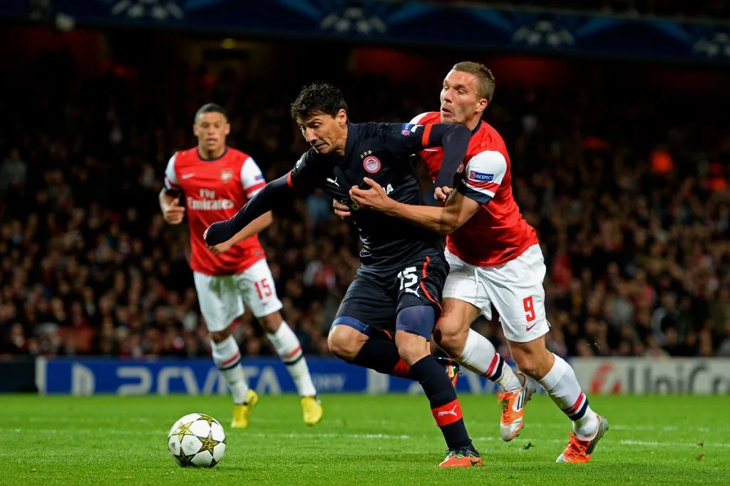 Pablo Contreras enfrenta al Arsenal a los meses de haber dejado Colo Colo. En la imagen resiste los embates del alemán Lukas Podolski. (Mike Hewitt/Getty Images).