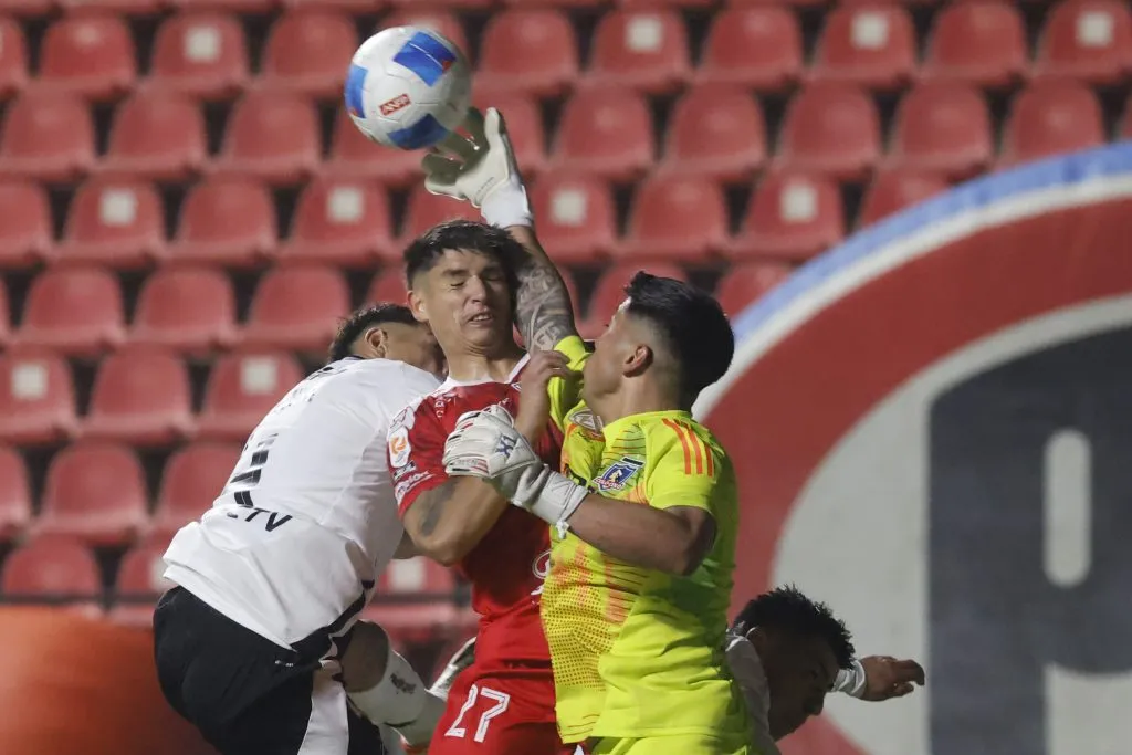 Brayan Cortés intenta alejar el peligro tras el cabezazo al travesaño de Lobos y ante la arremetida de Mesías. (Sebastian Cisternas/Photosport).