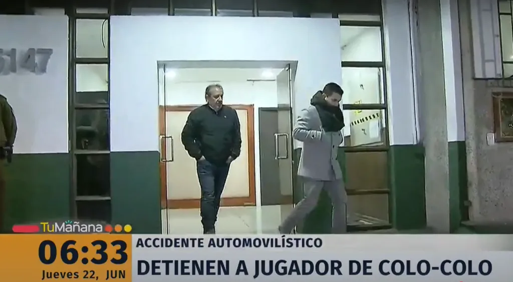 El representante Sergio Morales (con bufanda) y el entonces jefe de seguridad de Blanco y Negro, Luis Urzúa, salen de la comisaría. (Captura TVN).