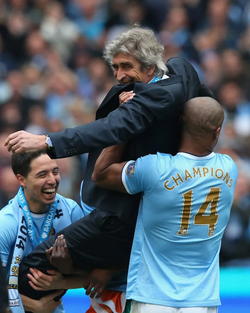 Samir Nasri y Vincent Kompany festejan el título del Manchester City en la Premier League junto a Pellegrini. (Alex Livesey/Getty Images).