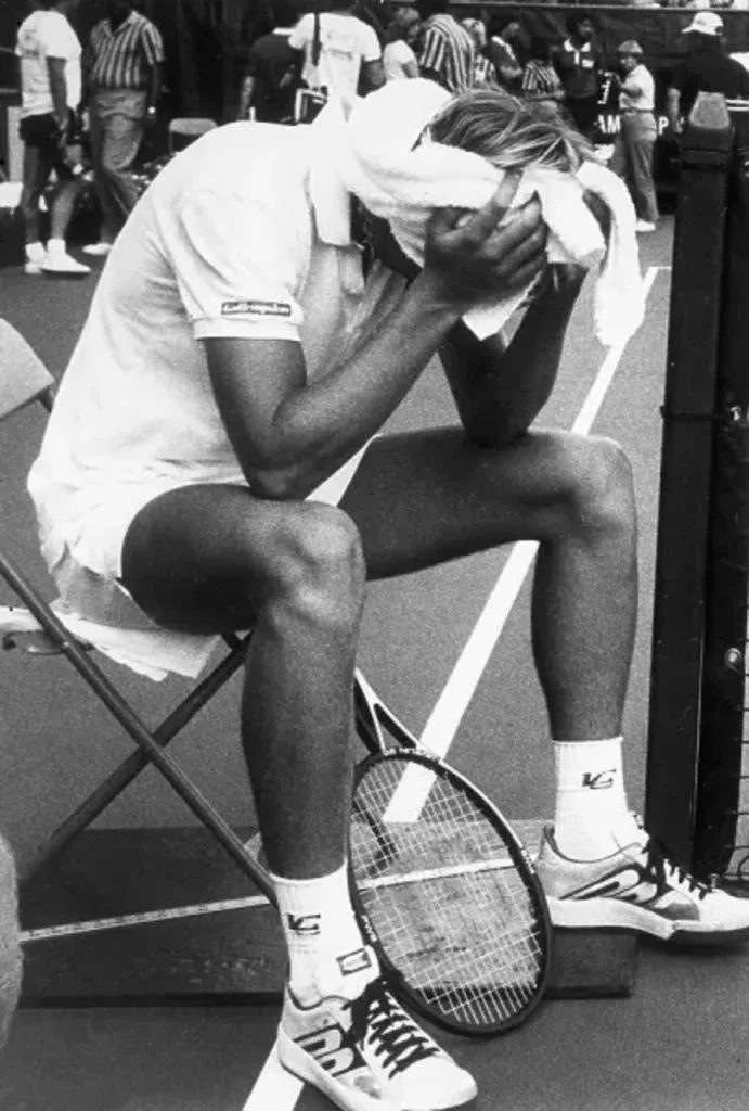 Stefan Edberg se tapa la cara tras golpear a Dick Wertheim con un saque de tenis.