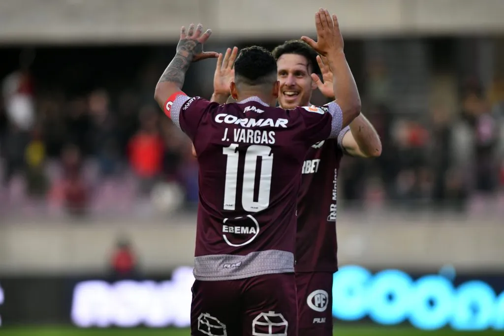 Jeisson Vargas celebra junto a Ángelo Henríquez, quien le dio una asistencia al “10”. (Alejandro Pizarro/Photosport).