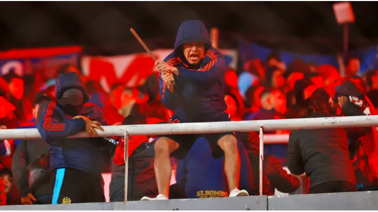 Los hinchas de la U comenzaron a lanzar objetos desde su tribuna.