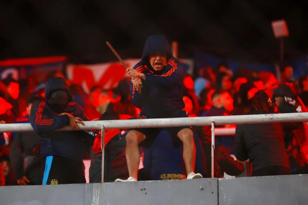 Los hinchas de Universidad de Chile comenzaron a lanzar proyectiles desde su tribuna hacia los seguidores de Independiente. | Foto: Photosport.