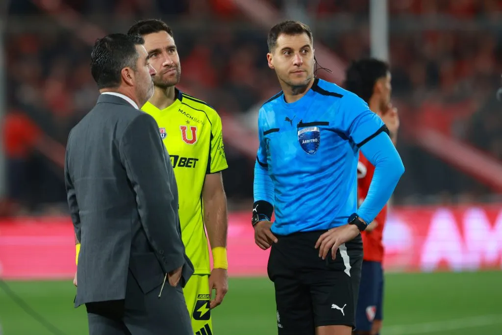 Matías Zaldivia y el árbitro Gustavo Tejera miran las imágenes terribles que se dieron en la tribuna Pavoni alta.  (Javier Vergara/Photosport).